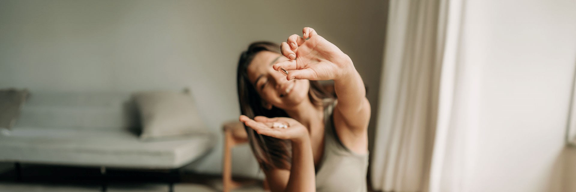 Smiling woman holding a supplement capsule