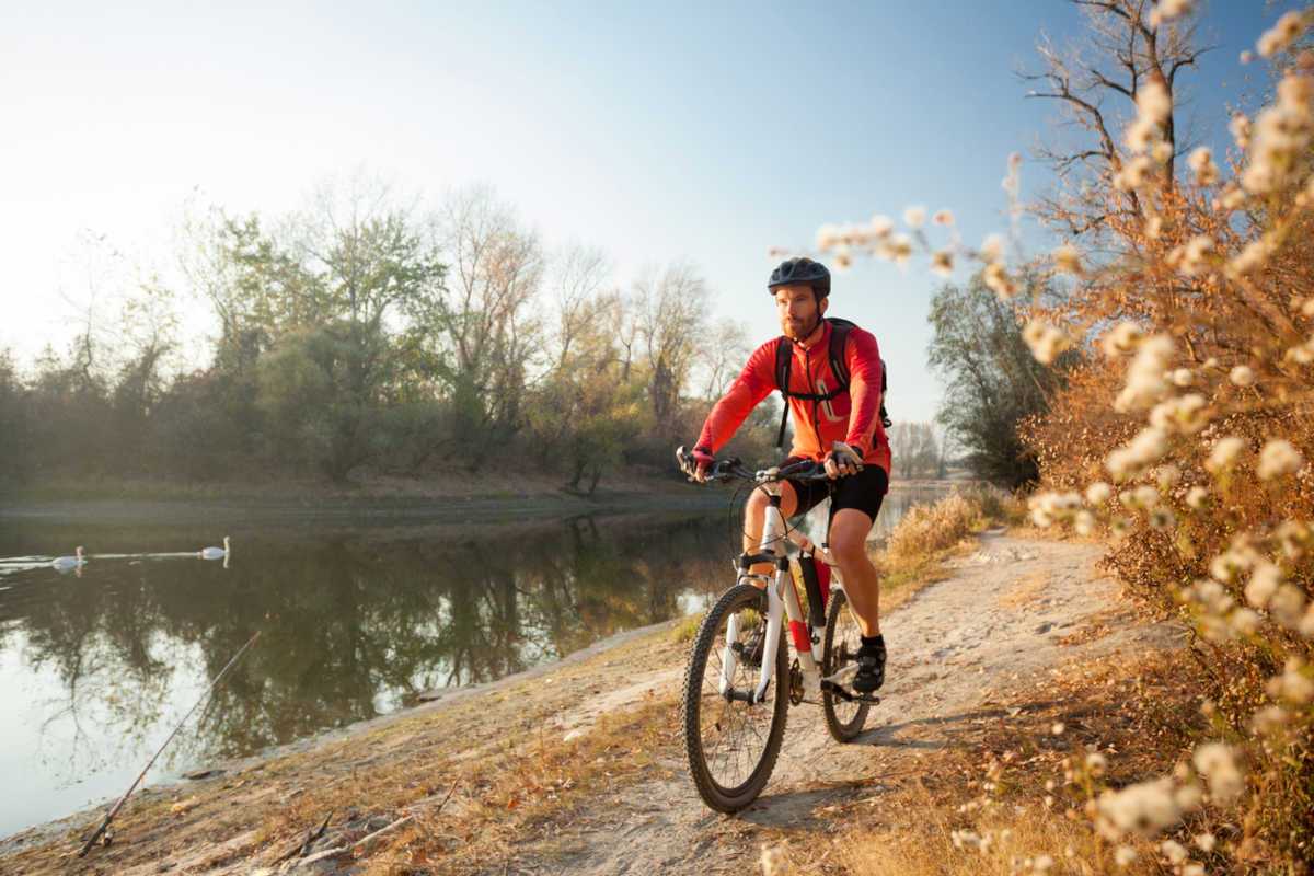 Man cycling beside river