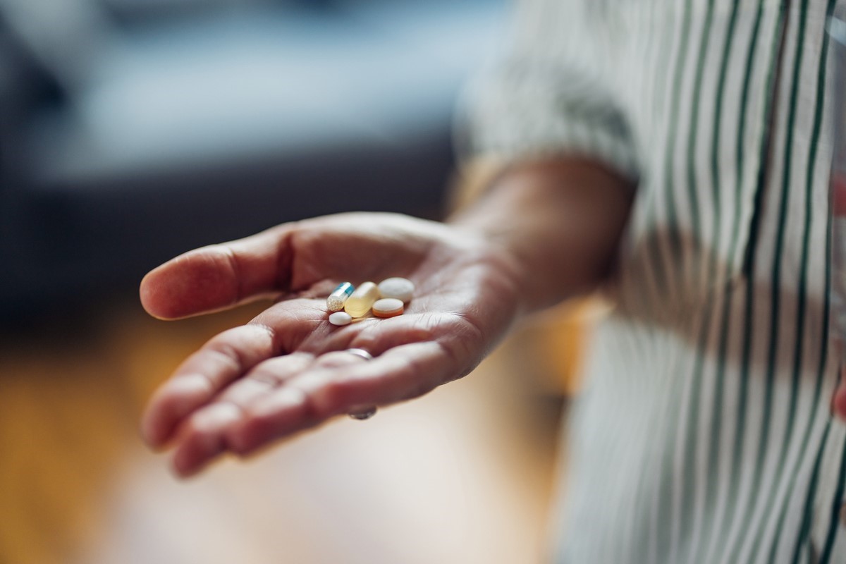 Person holding supplement tablets in hand