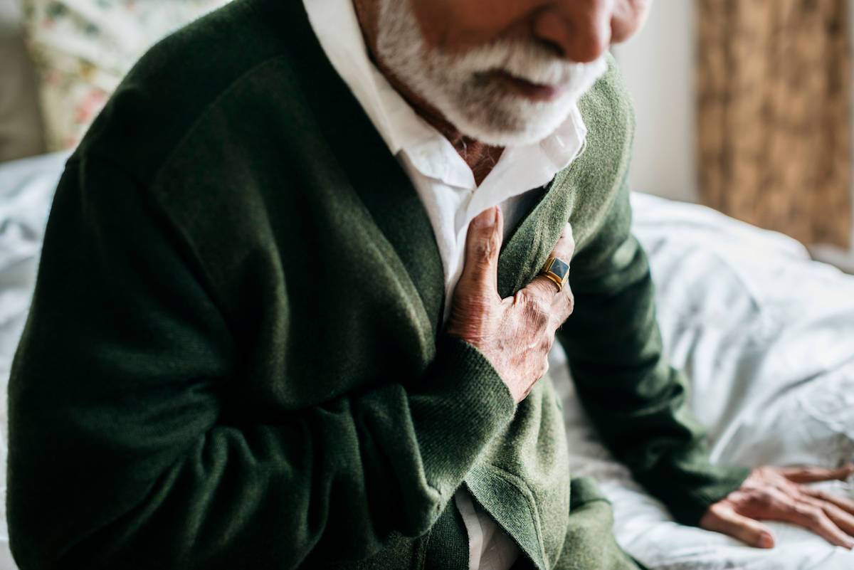 Man in discomfort holding chest