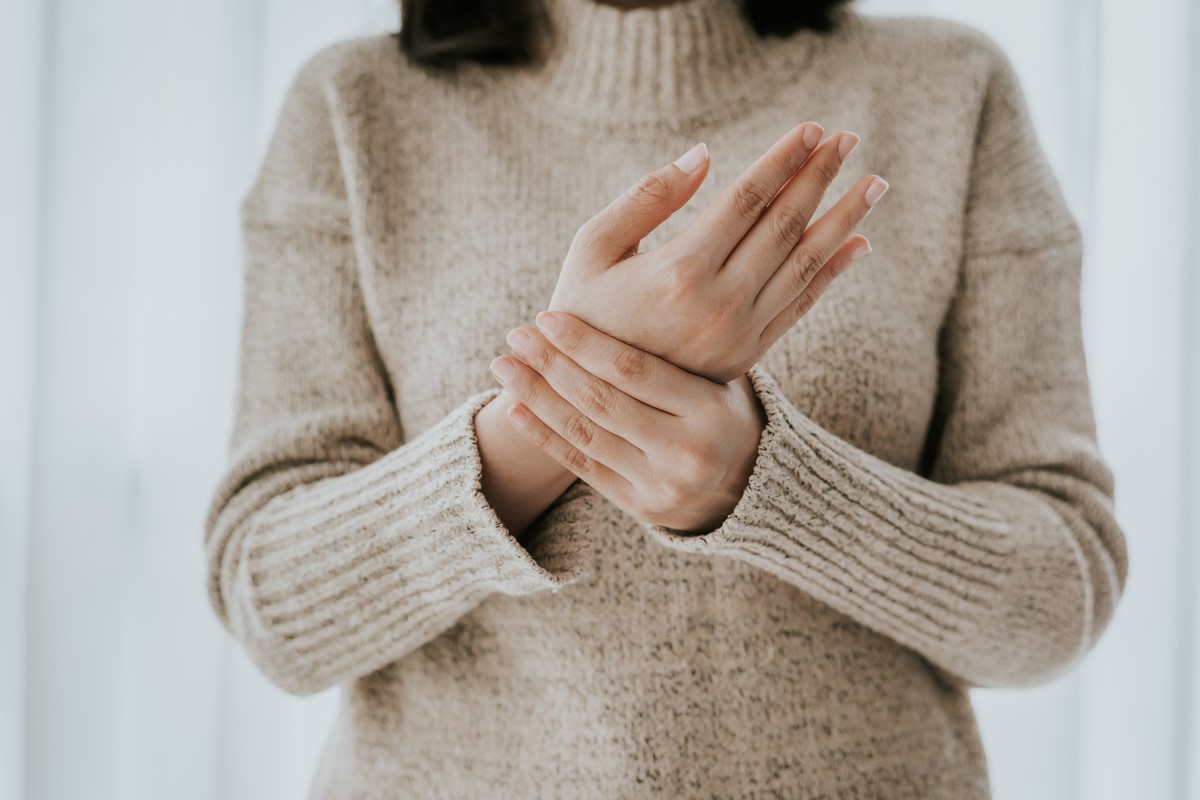 Woman holding her hand in pain